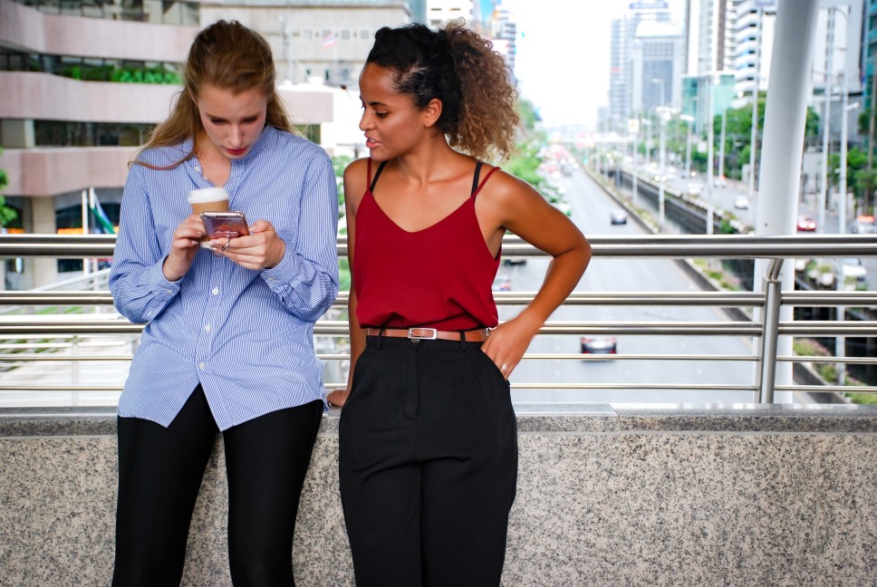 Two business women discussing something outside in the city