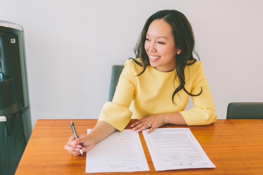 A business woman sitting at a desk with paperwork